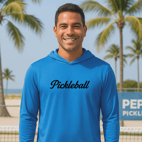 Man wearing a blue 'Pickleball' hoodie with palm trees and a court in the background